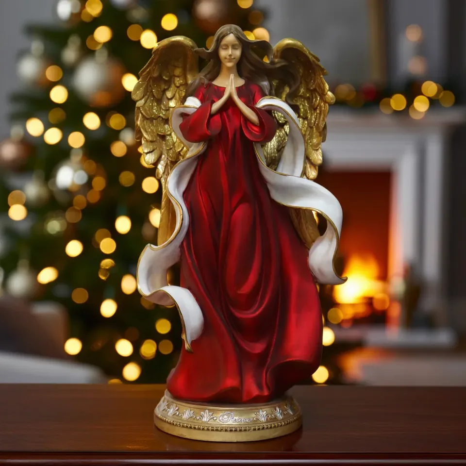 Angel figure with gold-colored wings, a red gown and a white ribbon detail.