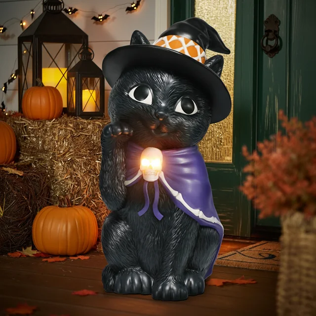 Black cat decoration wearing a pointed hat and holding an orb.