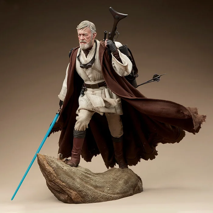 Obi-Wan character figure with a brown cloak and a blue lightsaber on a rock-like base.