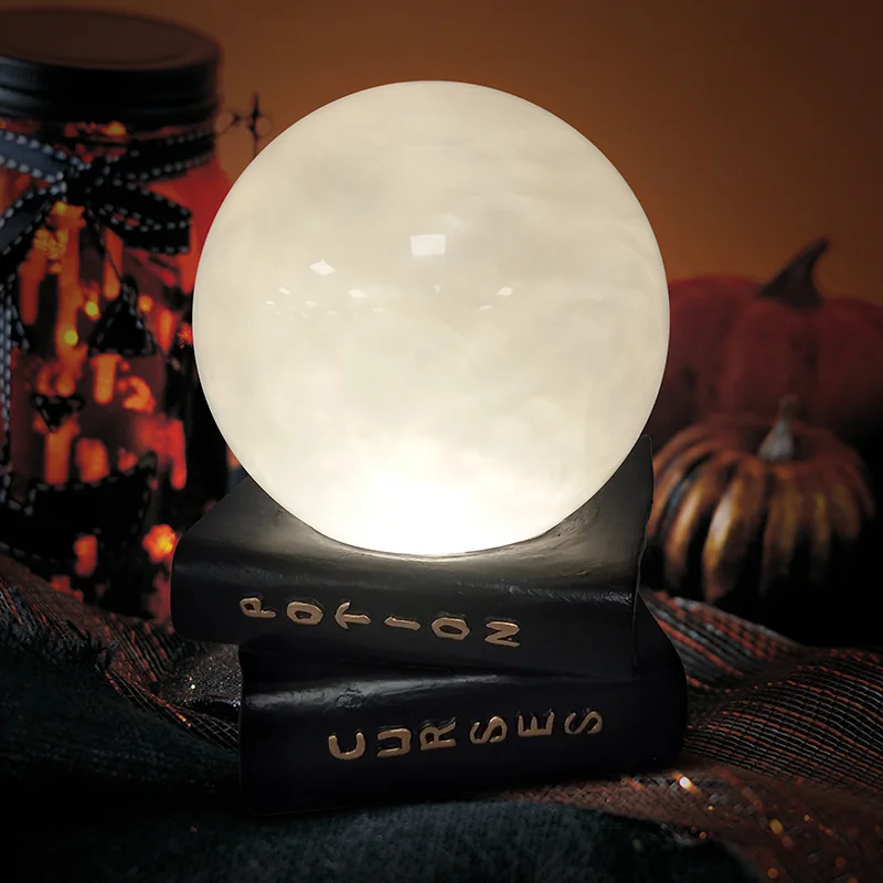 Round globe on a dark book-shaped base with decorative potion-themed markings.