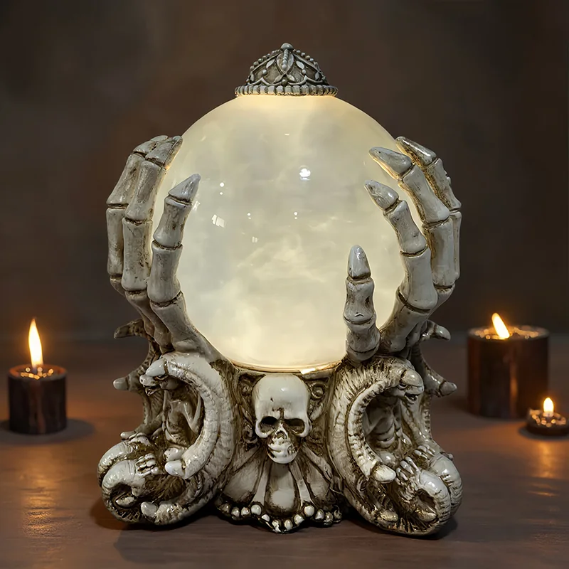 Skeleton-like hands surrounding a pale globe above a skull-decorated base.